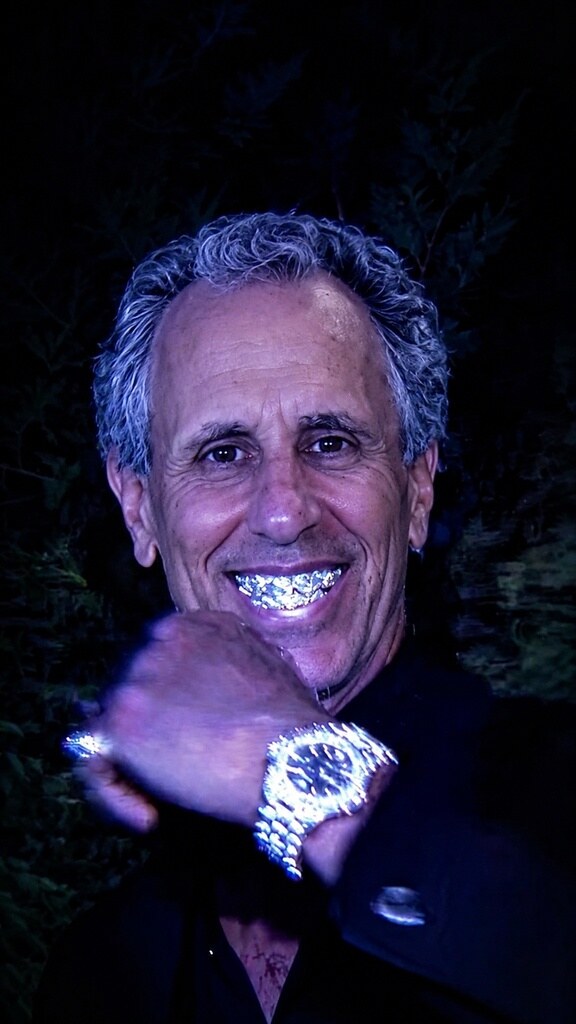 Fictional composite artwork showing Peter Spiegel wearing bright jewelry at night